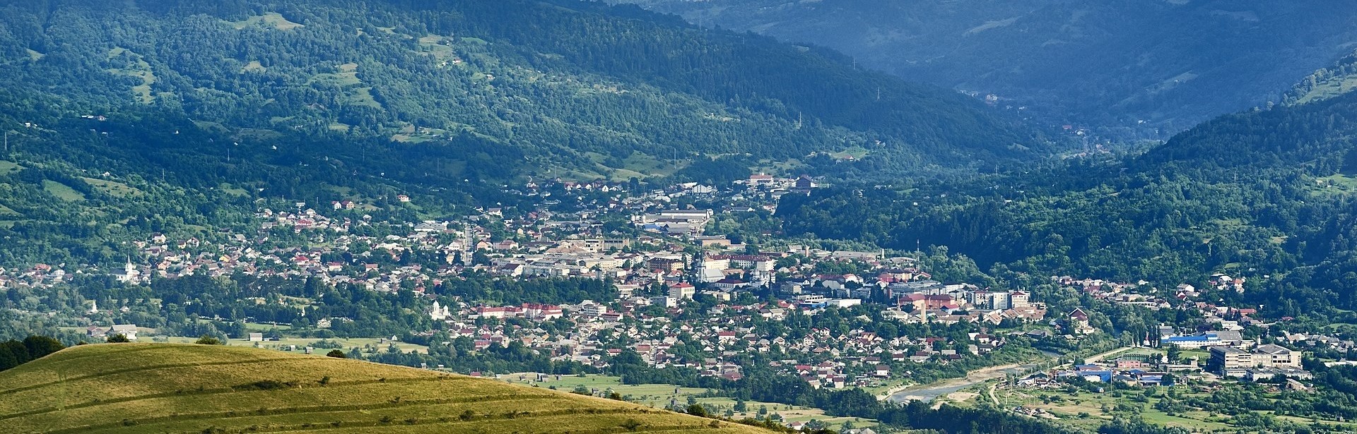 Vedere panoramică asupra orașului Vișeu de Sus, între dealuri împădurite